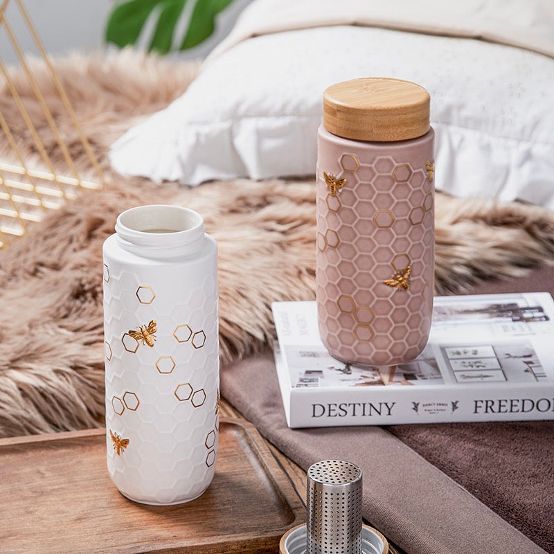 Experience pure taste and modern style with the ACERA Honey Bee travel mug. The tourmaline lining enhances the flavor and freshness of any beverage, while the handcrafted honeycomb design and golden honey bees on the ceramic outer layer create a unique look.